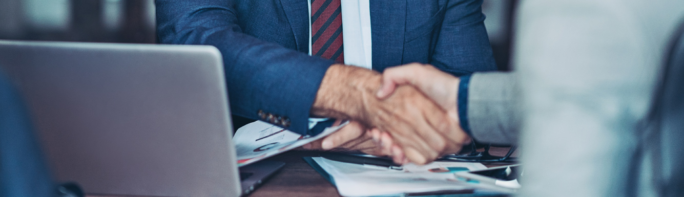 Men shaking hands at desk