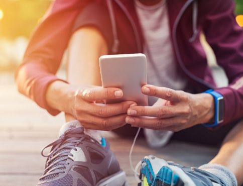 Picture of a mobile phone being held by man sitting on ground