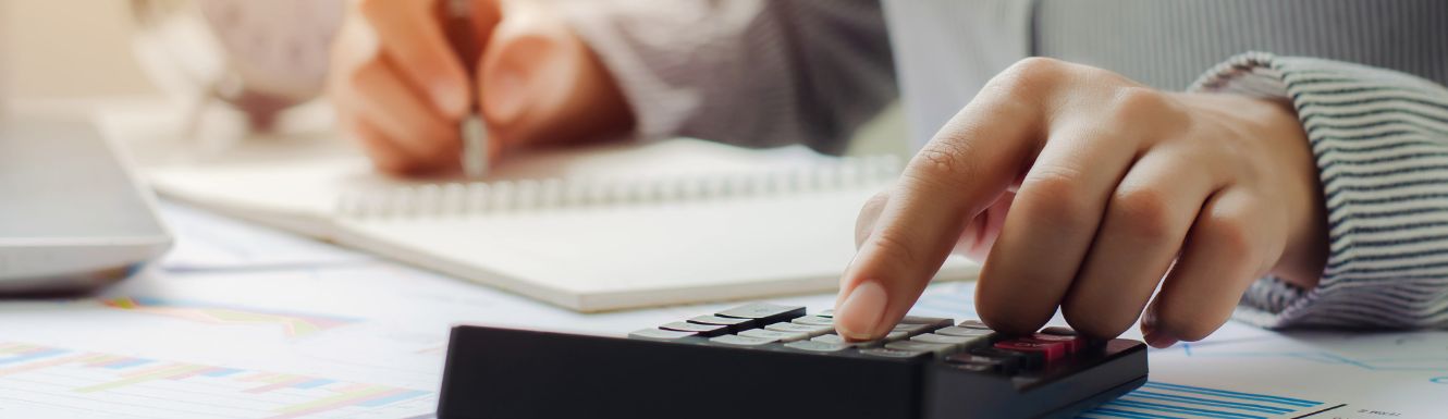 person typing in numbers on calculator