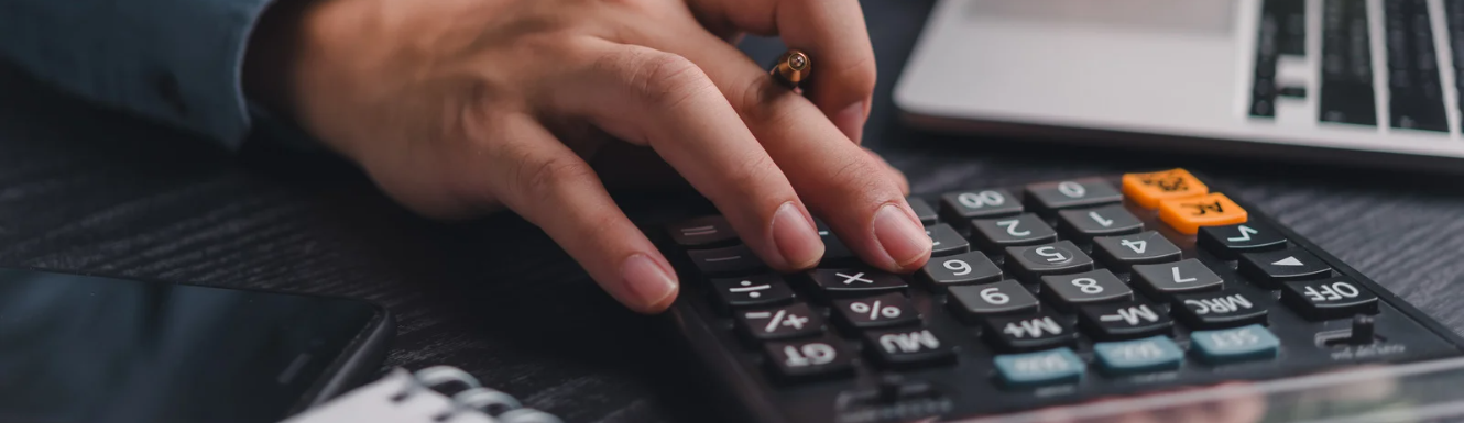 Person typing in numbers on their calculator