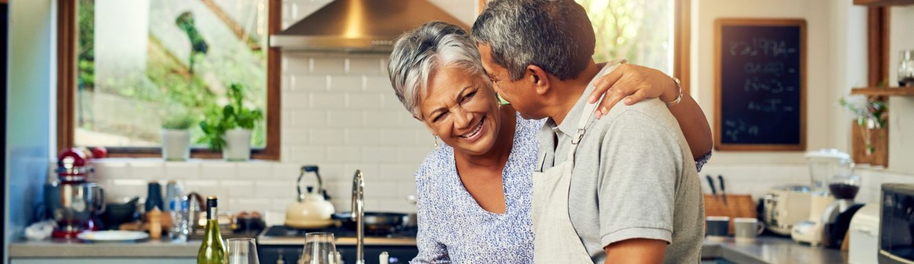 mature couple in kitchen smiling